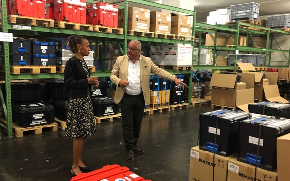 DEZA-Direktorin Patricia Danzi geht mit HH-Logistikchef Markus Hischier durch das Depot und schaut sich das Material an.
