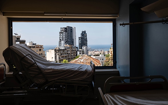 Blick auf ein Geburtsbett mit Blick aus dem Fenster auf die zerstörte Hauptstadt des Libanons.