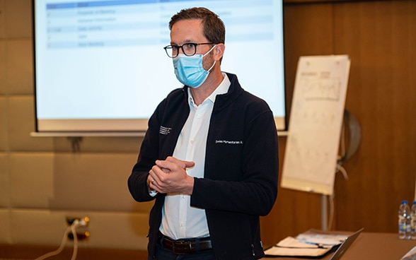 An expert from the Swiss Humanitarian Aid Unit provides information at a situation briefing.