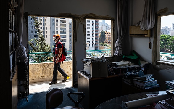 Blick aus einem Zimmer nach aussen. Die Fensterscheiben sind zerstört, Ingenieurin Regina Wenk prüft die Schäden am Gebäude.