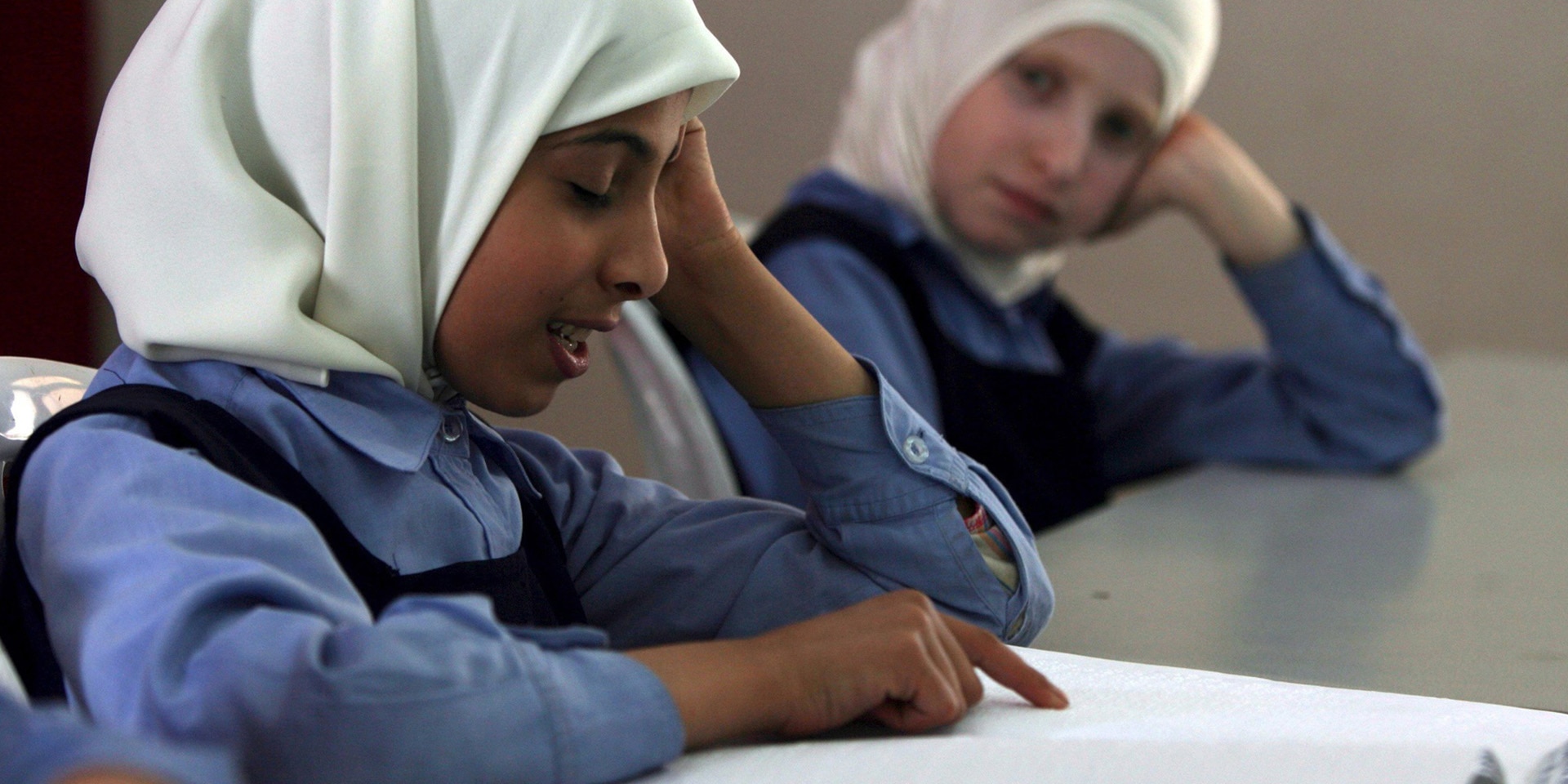 A blind girl in Gaza City reads a book in Braille.