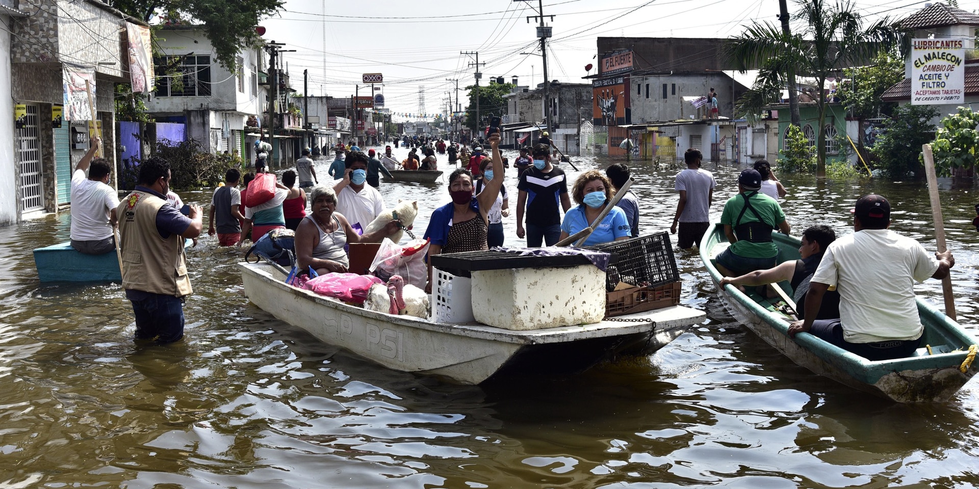 Anwohner überqueren eine von starken Regenfällen überschwemmte Allee nach dem Hurrikan Eta.