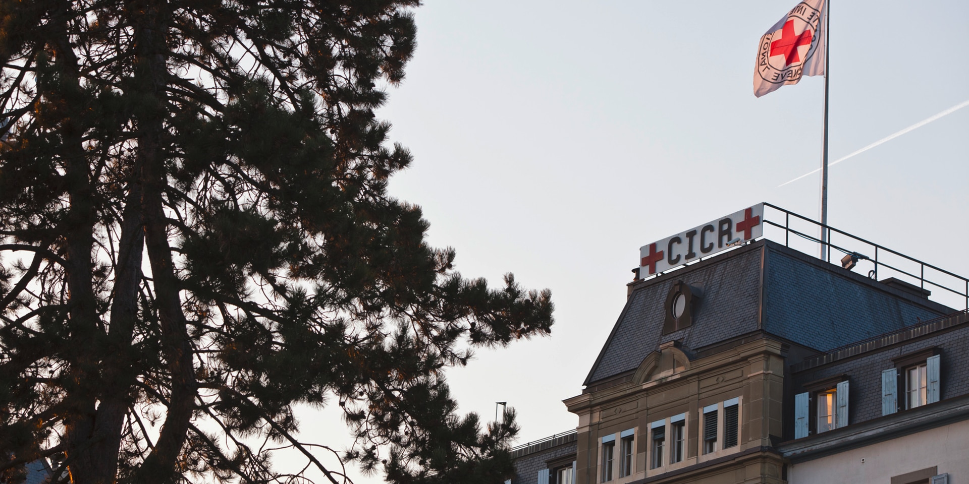 The famous ICRC emblem – a red cross on a white background – adorns a display panel and a flag on the roof of the ICRC headquarters.