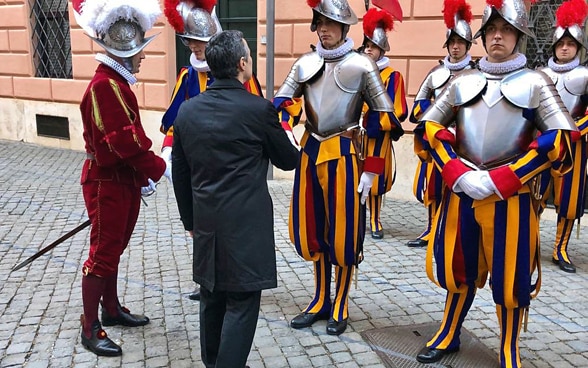 Le conseiller fédéral Ignazio Cassis serre la main d'un garde à l'occasion de la prestation de serment du Vatican le 6 mai 2019.