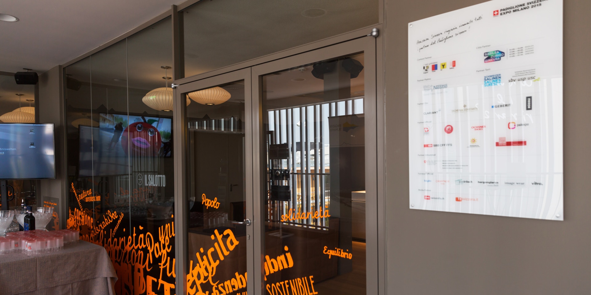 Un panneau blanc située à l’entrée d’un bâtiment détaille l’ensemble des partenaires du pavillon suisse lors de l’Exposition universelle de 2015 à Milan.