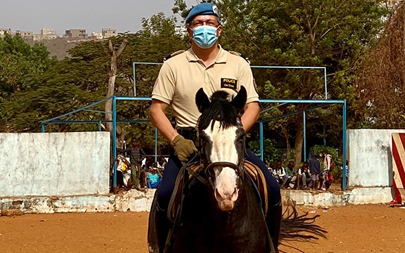 Carl Emery in sella a un cavallo marrone con le gambe nelle staffe.