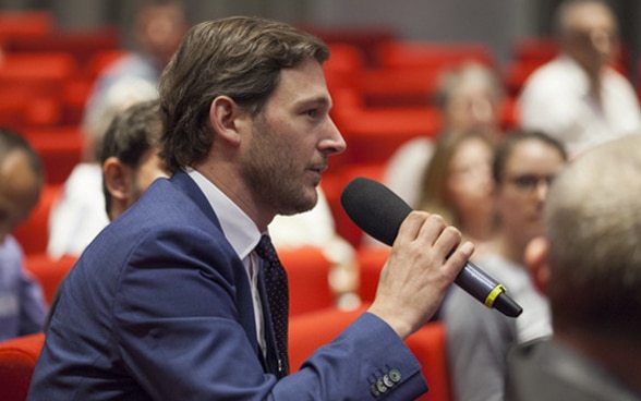  A man speaking into a microphone.