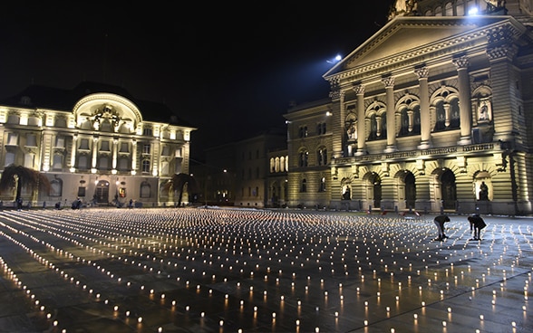 Aufnahme vom Bundesplatz in der Nacht, mit Kerzen als Mahnmal für die Opfer der Pandemie.