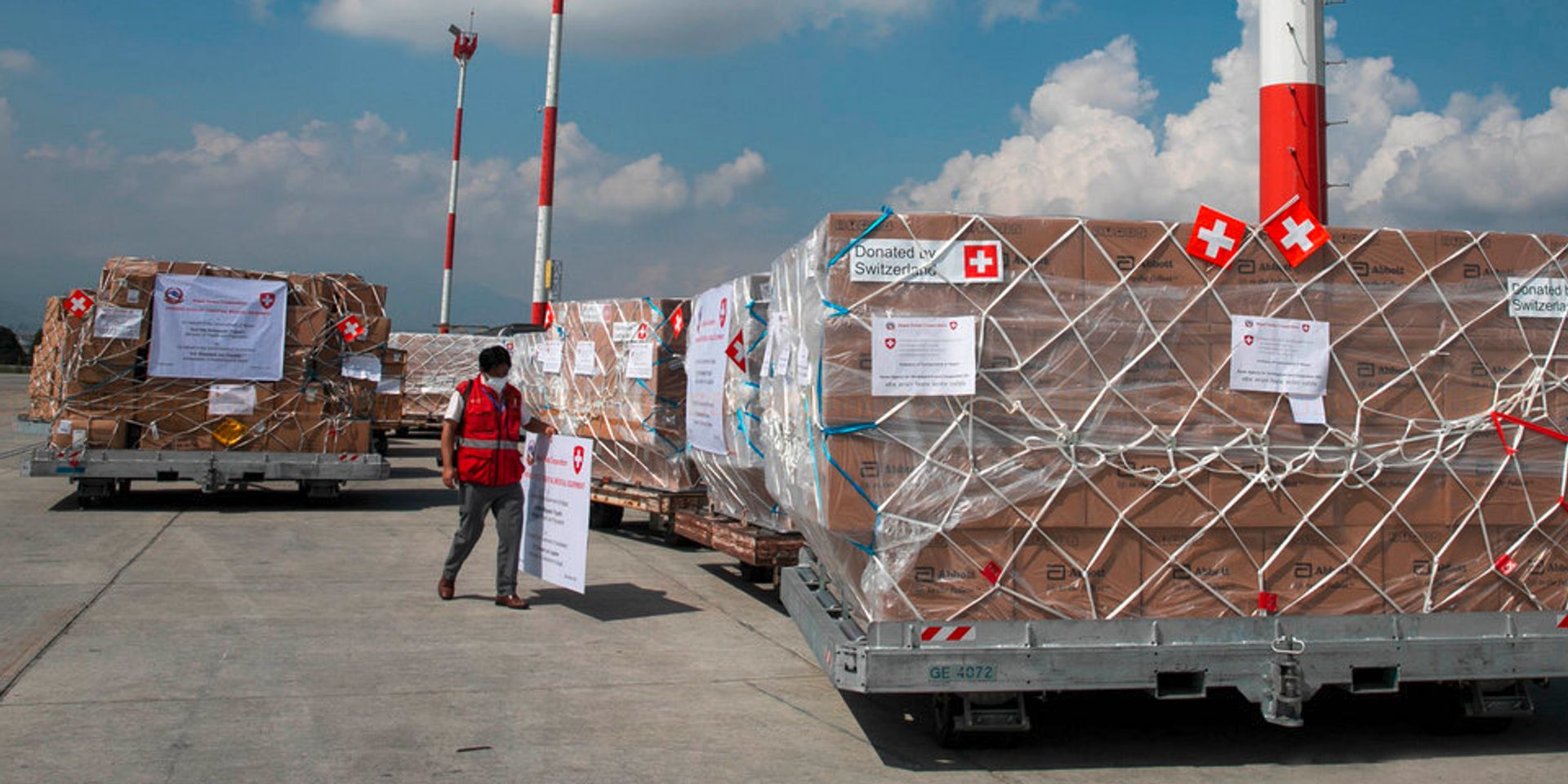 En el campo de aviación, un vehículo transporta un cargamento humanitario a un pabellón de almacenamiento. 