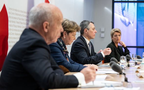 Quattro membri del Consiglio federale siedono di fronte a una platea composta da rappresentanti dei media.