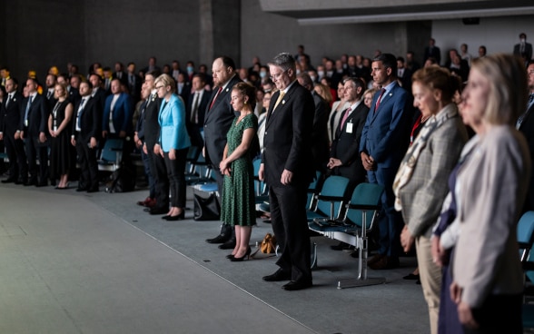 In the main hall of the Palazzo dei Congressi participants in the closing plenary session observe a minute of silence.