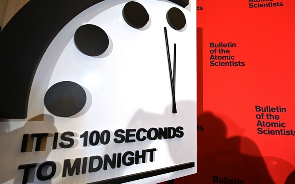 Eine weisse Uhr zeigt 100 Sekunden vor Mitternacht an. 