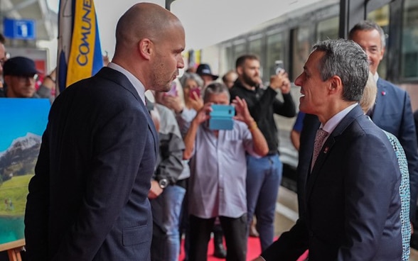 The President of the Swiss Confederation is welcomed on the platform of the Airolo railway station by the authorities and the population.