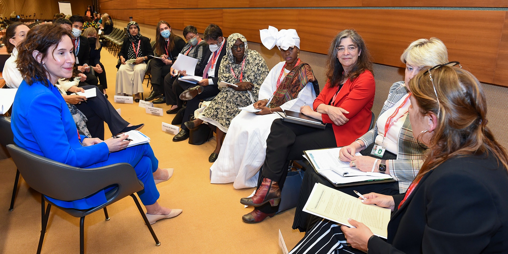 Un groupe de participants à la rencontre de Genève discute en cercle.