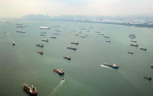 Frachtschiffe im Hafen von Singapur, die in die gleiche Richtung fahren. 