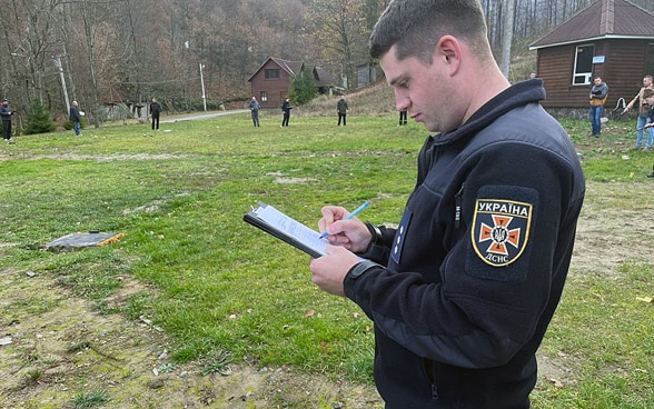 Un homme prend des notes sur un champ d’exercice.