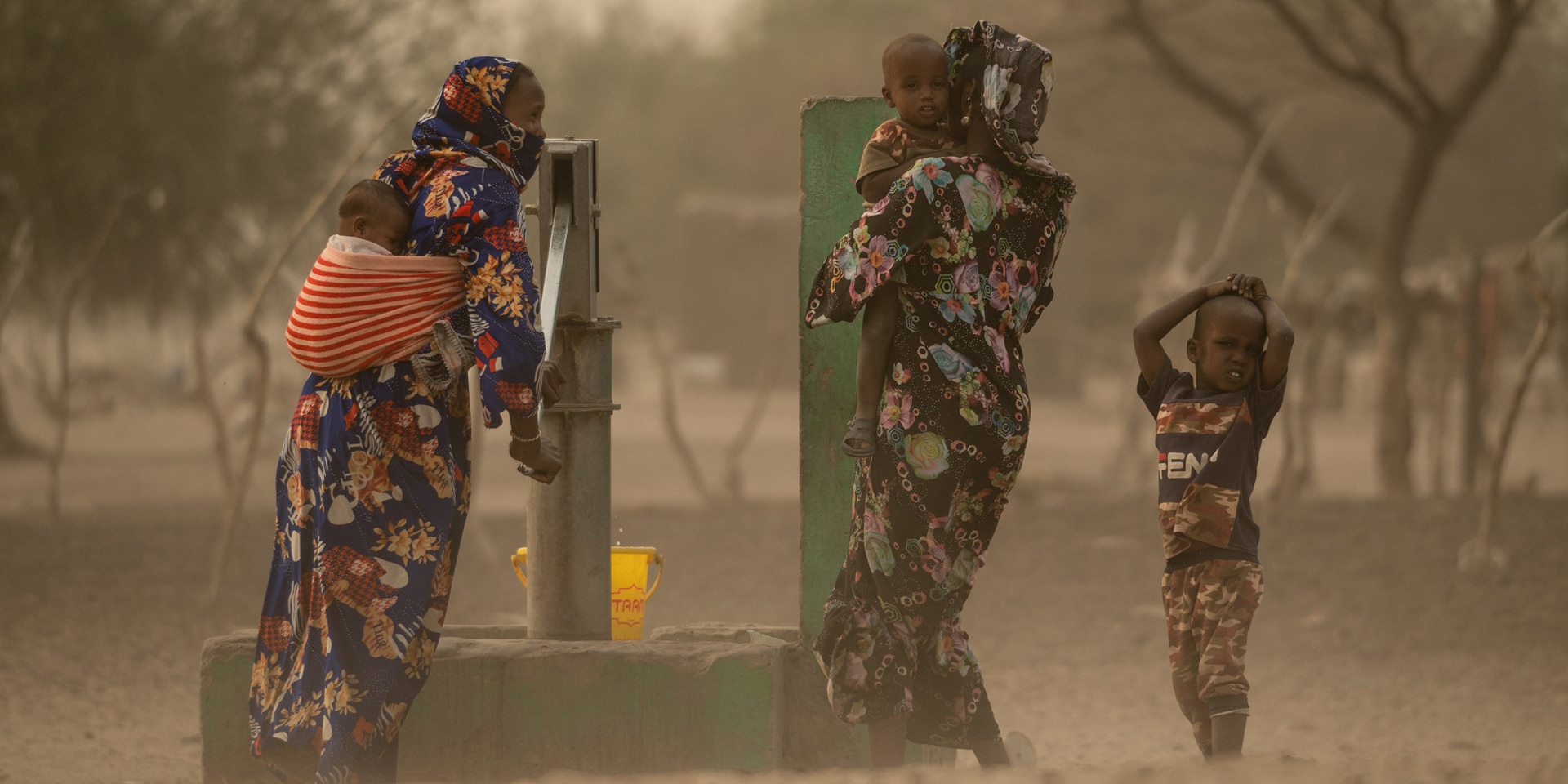 Afrikanische Frauen pumpen Wasser aus einem Brunnen im Tschad.