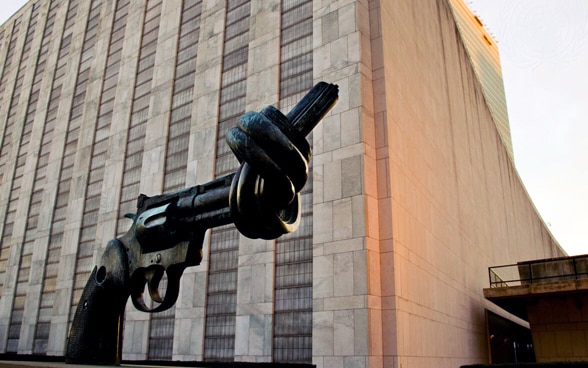 Eine Eisenskulptur in Form einer Pistole mit einem Knopf im Lauf steht vor dem UNO-Hauptgebäude in New York.