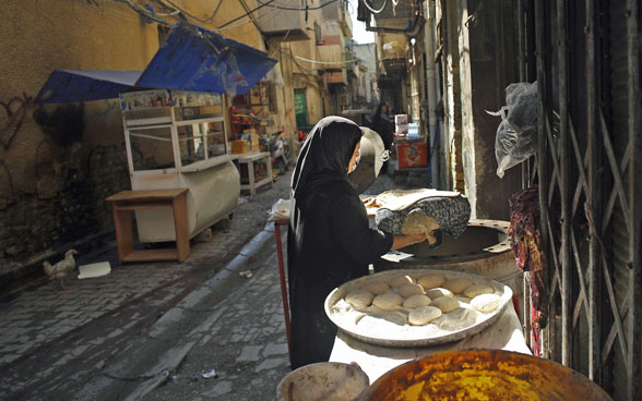 A woman bakes bread in the streets of Baghdad.