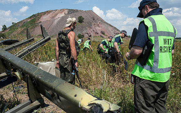 Investigatori internazionali al lavoro intorno ai resti dell’aereo della Malaysia Airlines caduto nell’Est dell’Ucraina nell’estate 2014