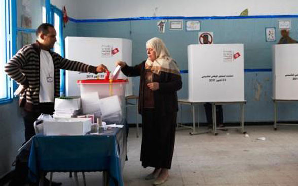 Eine Frau nimmt in Tunesien an den Wahlen teil.