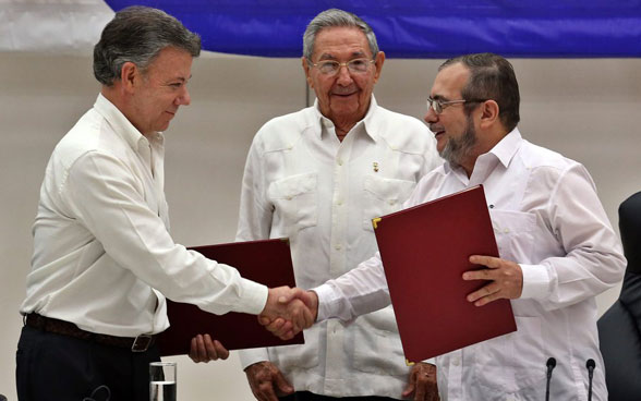 The Colombian president and leader of the FARC guerrillas shake hands at the signing of the peace accord in June 2016 in Havana, in the presence of Raoul Castro. 