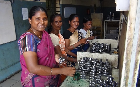 Ouvrières occupées au contrôle final de pièces automobiles dans une usine SCORE en Inde.