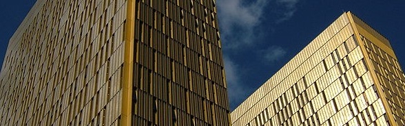 Die hohen Türme des Europäischen Gerichtshofs in Luxemburg glänzen goldfarben vor blauem Himmel.