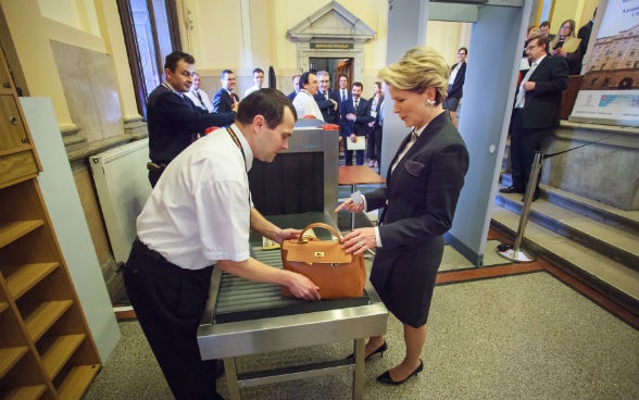 State Secretary Marie-Gabrielle Ineichen in front of a walk-through metal detector