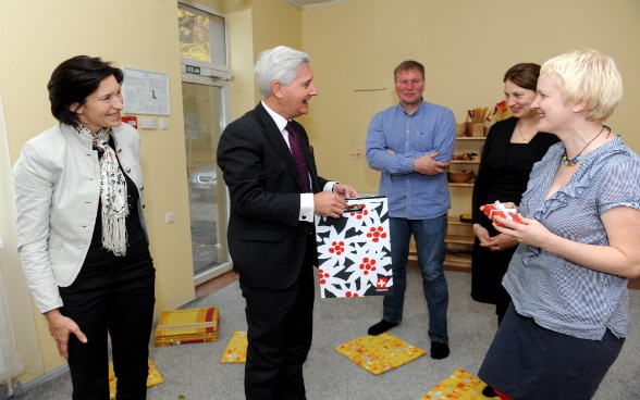 L’ambasciatore svizzero mentre consegna alcuni regali ai responsabili della scuola materna POGA per festeggiare la concessione del 1000° microcredito.