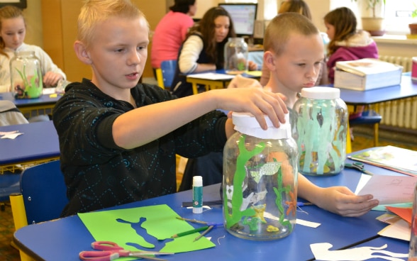 Schoolchildren doing crafts in the classroom.