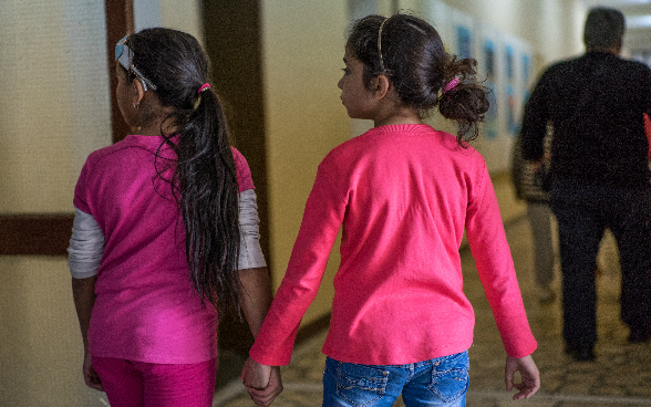 Two girls holding hands.