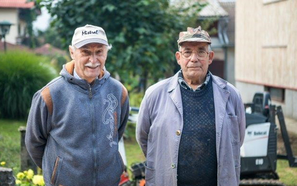 Deux retraités posent devant un chantier.