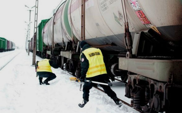 Two border guards check a train.