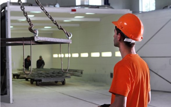 Un jeune homme portant un casque de sécurité travaille dans une usine.