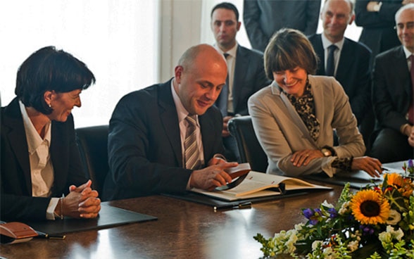 Federal Councillors Micheline Calmy-Rey and Doris Leuthard together with the Bulgarian minister responsible for administering the relief funds from the European Union, Tomislav Donchev, at the signing of the framework agreement between Switzerland and Bulgaria in Bern in 2010.